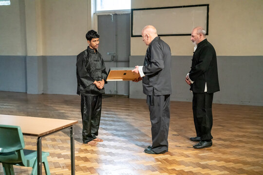 Man receiving kung fu black belt certificate