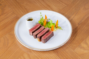 Medium Rare Wagyu Beef Steak with Sauce and Vegetables on White Plate
