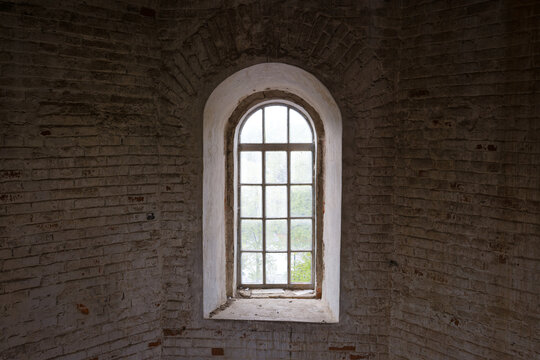 A window in a building with a brick wall