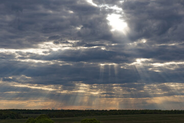 The sky is cloudy and the sun is shining through the clouds