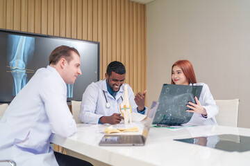 Obraz premium medical team discussing and review rare disease case to improve the practice guidelines,multiracial orthopedic doctors working in medical conference room