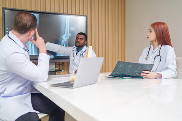 Obraz premium medical team discussing and review rare disease case to improve the practice guidelines,multiracial orthopedic doctors working in medical conference room