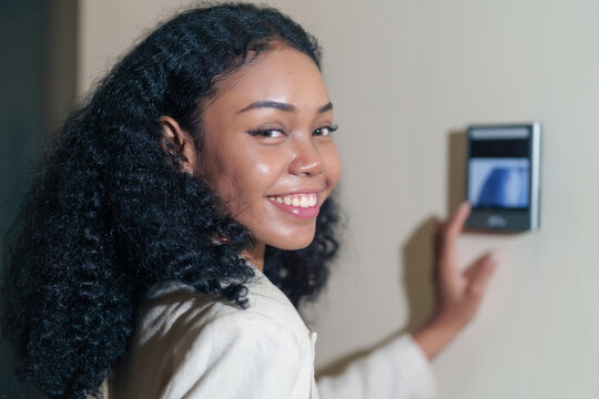 emale african company employee with curly hair portrait headshot young female african company employee with curly hair standing at time attendance scanner,scanning fingerprint to enter security system