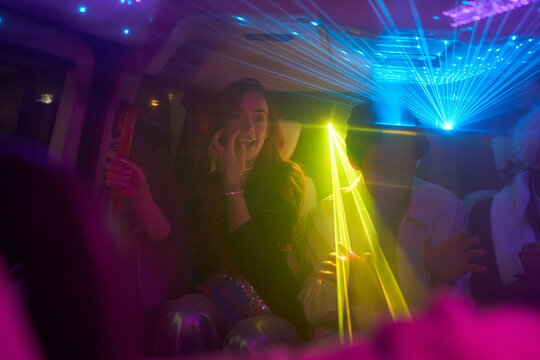 Group of young people inside car with laser show