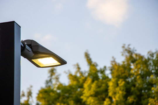 LED street light switched on with yellow light for energy savings.