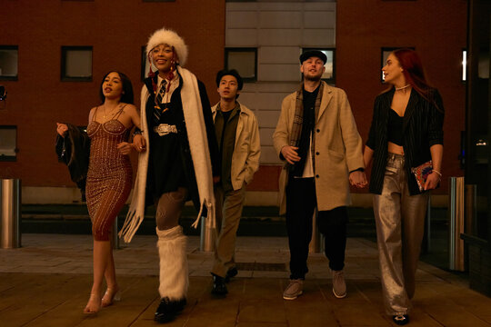 Group of young people walking in street at night
