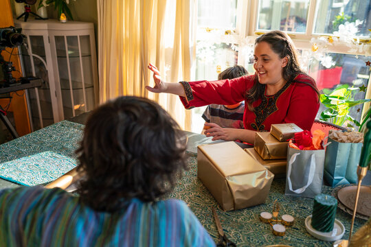 Adult siblings with little sister preparing gifts for Eid Celebration