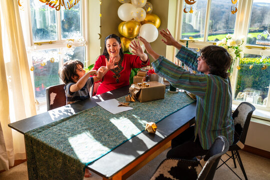 Adult siblings with little brother preparing gifts for Eid Celebration