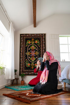 Mother and adult daughter praying during Eid Celebration
