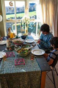 Young man with little sister dining during Eid Celebration