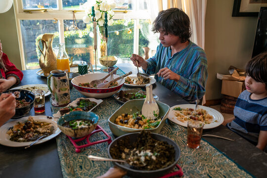 Young man with little sister dining during Eid Celebration
