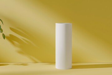 Minimal white cylindrical vase against a yellow backdrop with shadows