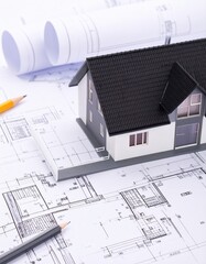 Model of new house with black tiled pitched roof on architecture blueprint plan