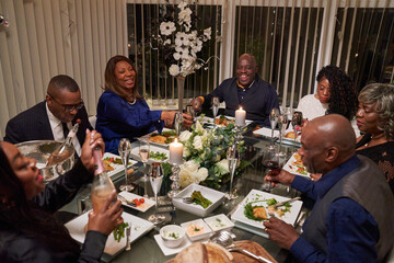 Group of friends having dinner while celebrating silver wedding anniversary