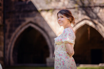 Woman in Floral Dress Standing by Historic Stone Building