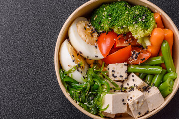 Vegan salad, bowls with chickpeas, broccoli, tomatoes, tofu cheese and boiled eggs