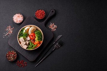 Vegan salad, bowls with chickpeas, broccoli, tomatoes, tofu cheese and boiled eggs