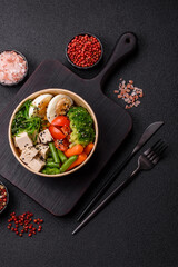 Vegan salad, bowls with chickpeas, broccoli, tomatoes, tofu cheese and boiled eggs