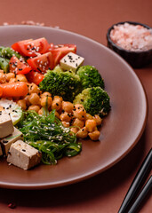 Vegan salad, bowls with chickpeas, broccoli, tomatoes, tofu cheese and boiled eggs