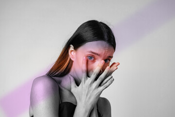 Model poses with hands covering her face, revealing emotions through a striking black and white...
