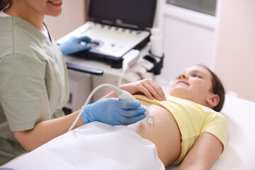 Sonographer conducting girl's abdominal ultrasound examination in clinic, closeup