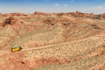 SUV car moving on dusty road at Pingshan Hu Grand Canyon in summer, Zhangye City, Gansu Province in China