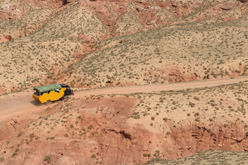 SUV car moving on dusty road at Pingshan Hu Grand Canyon in summer, Zhangye City, Gansu Province in China