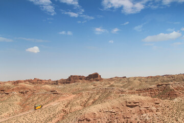 SUV car moving on dusty road at Pingshan Hu Grand Canyon in summer, Zhangye City, Gansu Province in China