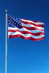 Obraz premium A large flag with red and white stripes and white stars on a blue field waving against a clear bright blue sky, symbolizing patriotism and pride