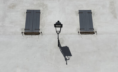 A lonely lantern on the wall between two windows
