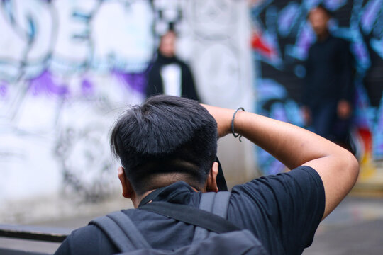a photographer doing a prewedding photo with a couple in a graffiti background