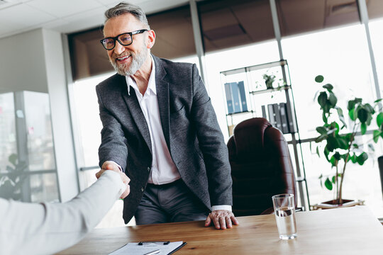 Senior professional greeting in a modern office highlighting collaboration during a productive business meeting
