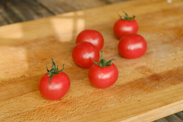 Red fresh tomatoes on wooden cutting board