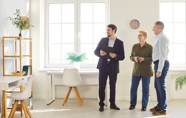 Real estate agent or realtor presenting a new home to an elderly couple before a potential purchase or rent. Engaging with clients to explore housing options and finalize property decisions.