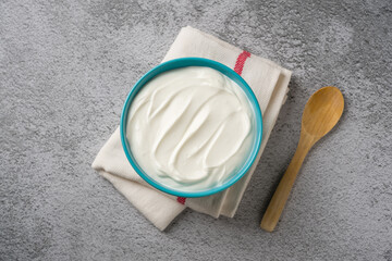 Top view of yogurt in bowl on grey stone table. Healthy eating concept