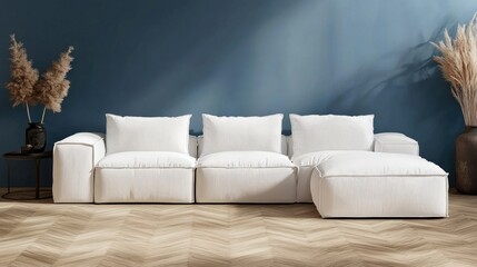 White sectional sofa in a modern living room with blue walls and herringbone flooring