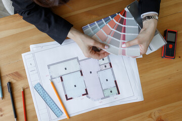 Architect reviewing interior design options for residential projects on design plans at workspace
