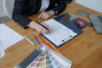 Architect designing housing projects in a modern workspace while reviewing plans and sketches