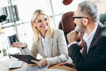 Friendly coworkers having a productive discussion in a modern office creating a collaborative professional atmosphere