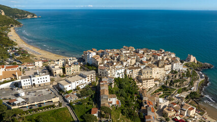 Obraz premium Aerial view of the town of Sperlonga, in the province of Latina, Lazio, Italy. The village is built on a promontory overlooking the Mediterranean Sea. In the background is the city beach.