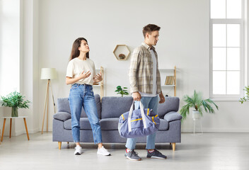 Sad husband leaves from wife at home after a family conflict, quarrel or divorce. Emotional strain...