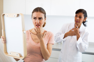 European middle age woman being very surprised and upset after the cosmetic procedure in aesthetic...