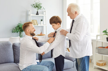 Cheerful multi generation male family wearing white shirts dressing, fixing outfits and preparing...