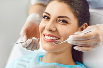 Portrait of happy smiling woman looking cheerful at camera sitting in dentistry clinic during...