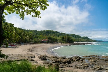 Tropical beach with lush greenery and turquoise waters.