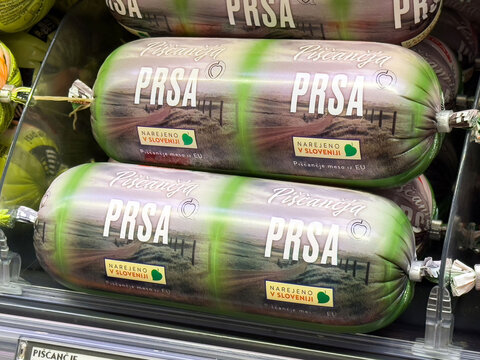 Slovenian chicken sausage packaging with green design in supermarket display