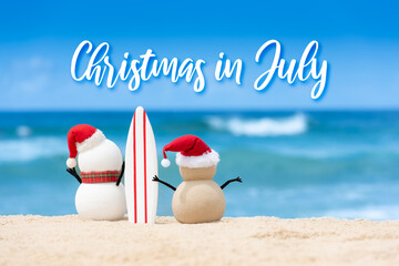 Christmas in July sale template design with a snowman and a sandy snowman on a beautiful beach, both holding a surf board