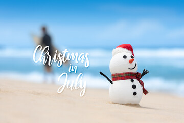 When snowmen need a break too. Beach day for a snowman. Surfer walking with surfboard in the background