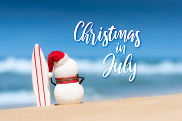 Christmas in July sale template design with a snowman on a beautiful beach, standing with a surf board.