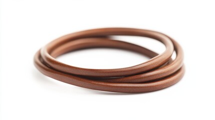 Fototapeta premium Coiled brown rubber band lies on a white surface ready for organizing papers or securing items together.